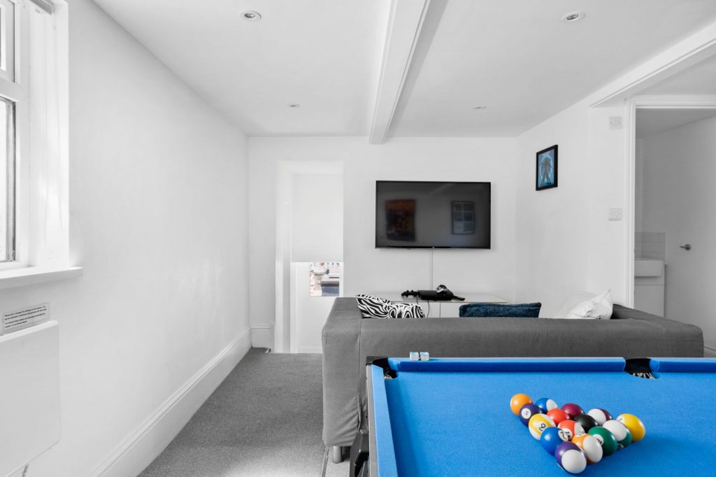 The games room, with pool, air hockey and a large screen TV with games console 